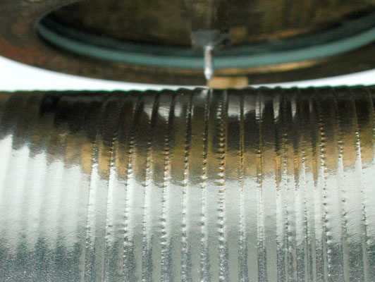 Der Stichel schreibt die Tonspur als kleine Einbuchtungen in die Zinfolie / The engraver writes the suondwave as hill and dale track